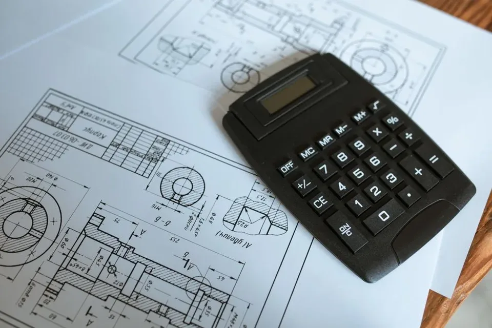 Calculatrice posée sur des plans, chiffrage d’un chantier.
